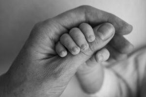 newborn baby has firm grip parent s finger after birth close up little hand child palm mother father parenting childcare healthcare concept black white photo 1