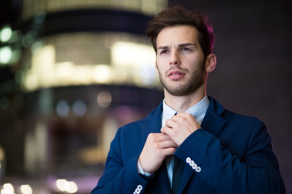 An employee in suit holding his tie